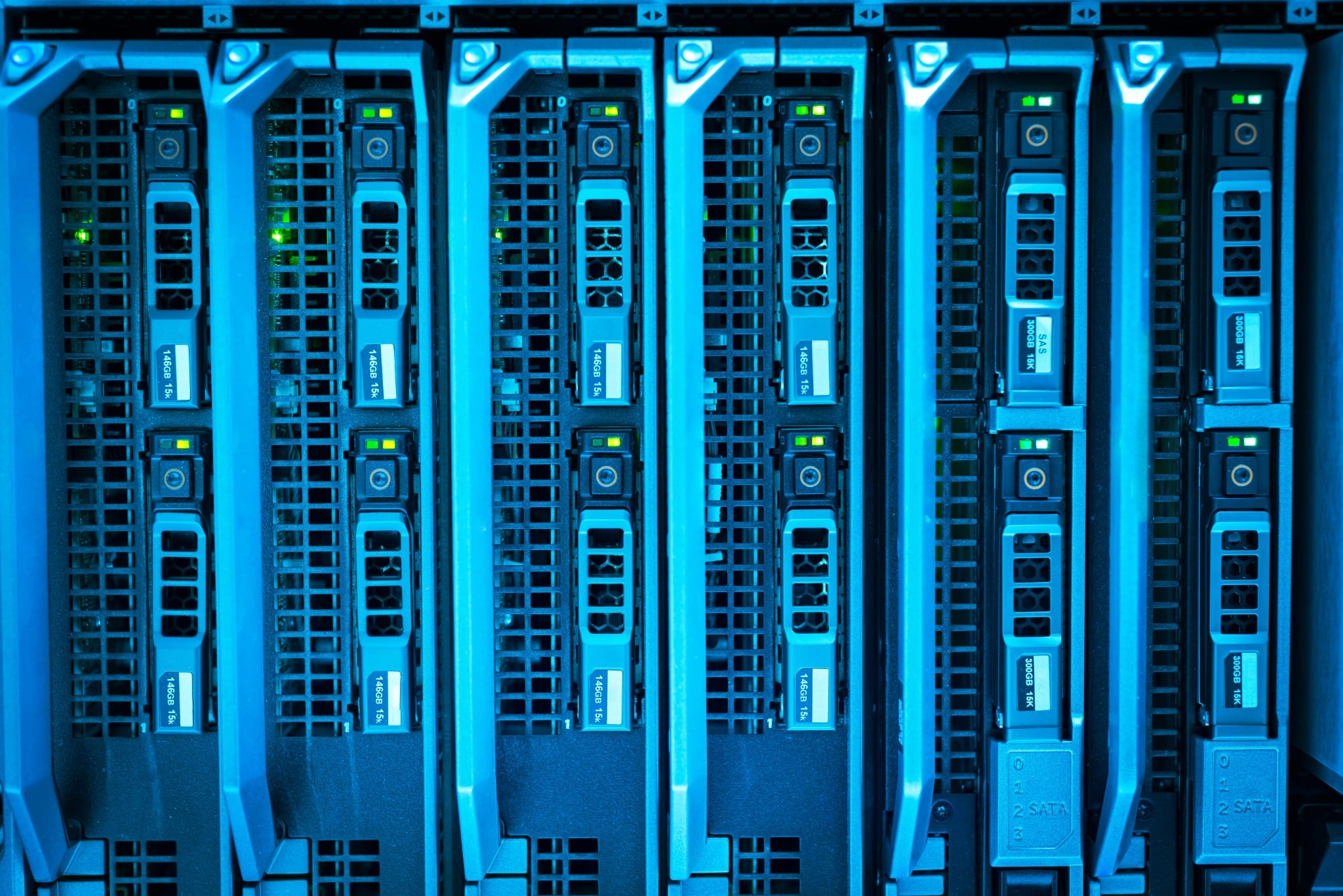 Close-up of enterprise server racks with illuminated data storage drives in a data centre.